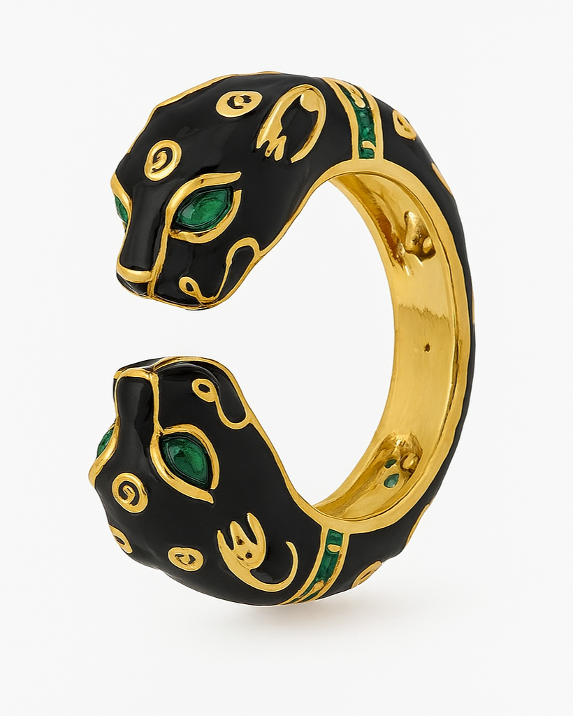 Gold and black panther-shaped ring with green eyes on a white background