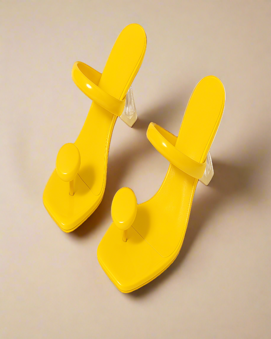 Pair of yellow high-heeled shoes on a white background